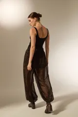 Pantalon de viscosa con diseño holgado, estampado animal print en tonos marrones y negros, cintura elástica y puños ajustados en los tobillos.