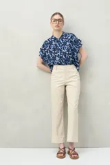 Pantalón recto de algodón color beige claro, con calce relajado y bolsillos de parche frontales.