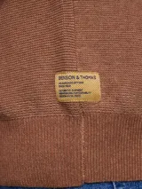 Sweater de punto color camel, con cuello redondo y mangas largas con puños acanalados.