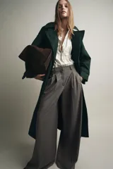 Pantalón de tiro alto con pierna ancha, confeccionado con detalle de pinzas en el delantero, bolsillos laterales y cierre frontal con cremallera y gancho metálico.