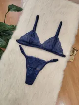 Conjunto de lencería compuesto por un corpiño triangular y una bombacha tipo colaless, ambos confeccionados en encaje de color azul profundo con detalles de malla.