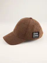 Gorra de béisbol de pana color marrón, con parche rectangular negro con el logo de Benson & Thomas en el lateral.