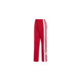 Pantalón deportivo Adidas Adibreak color rojo con bandas laterales blancas y botones a presión en los laterales.