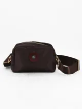 Bandolera de diseño rectangular en color chocolate, confeccionada en material sintético con acabado liso. Cuenta con cierre superior, correa ajustable al tono y un detalle circular decorativo en el centro del frente.