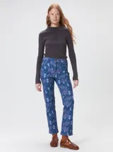Pantalón de jean de tiro medio con corte de pierna recta y ajuste cómodo. Presenta un estampado integral con motivos geométricos y abstractos en tonos azules.