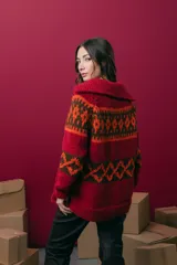 Saco tejido a mano con diseño jacquard, de corte recto y largo a la cadera. Presenta cuello redondo, cierre frontal con botones y mangas largas. Incluye tajos laterales en el ruedo.