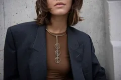 Gargantilla rígida plateada con dije vertical de tres espirales.