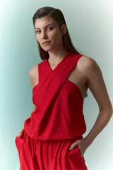 Mono rojo con cuello halter, corte holgado y pierna ancha.