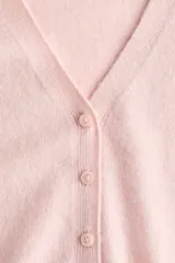 Cardigan de punto suave color rosado, con escote en V, cierre frontal de botones y puños y dobladillo acanalados.