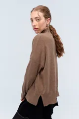 Polera tejida de punto confeccionada en lambswool color gris claro, con cuello alto y calce holgado.