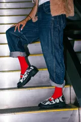 Mocasines estilo Mary Jane con diseño de estampado de vaca (cow print), confeccionados en cuero. Presentan una tira con hebilla ajustable sobre el empeine y una suela track negra de 4,5 cm de altura.