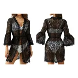 Vestido corto de encaje negro con diseño floral, escote en V profundo y mangas largas acampanadas. Presenta terminaciones con bordes festoneados.