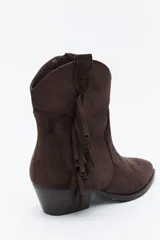 Bota texana de gamuza negra con caña baja, flecos laterales decorativos, costuras estilo western y taco bajo inclinado.