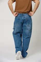Jean baggy de color azul claro, estilo carpintero, con bolsillos laterales utilitarios y corte ancho de pierna recta.