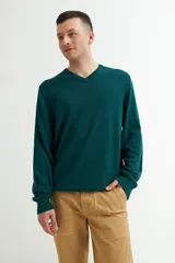 Sweater verde oscuro de tejido de punto, con escote en V y mangas largas.