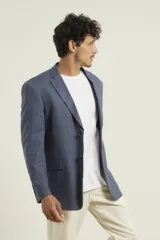 Saco azul de lino con dos botones, solapa de muesca, dos bolsillos delanteros con solapa y un bolsillo en el pecho.