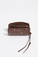 Billetera monedero de piel color marrón de Bimba y Lola, con estructura rígida y estampado de pequeñas palmeras doradas. Cuenta con cierre de cremallera superior con tirador de tela, logo impreso en el frente y tarjetero interior.
