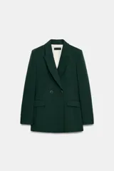 Blazer cruzado de color verde oscuro, con cuello de solapa, manga larga, bolsillos delanteros con solapa y cierre frontal con dos botones dorados.
