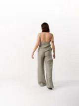 Pantalón largo de lino color gris, de corte holgado, con cintura elástica ajustable con cordón, dos bolsillos laterales y un bolsillo trasero.