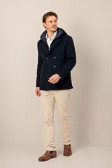 Campera de paño azul marino con diseño de doble abotonadura, que incluye un chaleco interior acolchado con capucha de nylon desmontable.