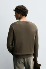 Jersey de punto con cuello redondo y manga larga, confeccionado en mezcla de algodón con textura de hilo torzal y acabados en rib.