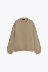 Jersey de punto liso con diseño oversize, cuello redondo y manga larga con puños acanalados.