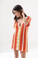 Vestido corto tejido calado a rayas horizontales en tonos naranja, amarillo y blanco, con cuello tipo polo y cierre frontal con botones.