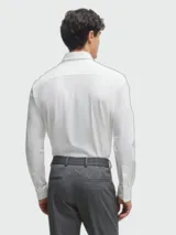 Camisa blanca de manga larga con corte slim fit, confeccionada en punto elástico técnico, con cuello clásico y cierre frontal de botones.