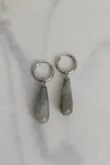 Aros tipo argolla de acero quirúrgico con dije colgante en forma de gota de piedra natural en tono marrón.