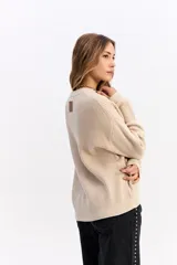 Sweater de tejido acanalado en color beige, con cuello redondo y diseño de calce relajado.