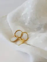 Par de aros dorados con forma de argolla, con dije circular de nácar.