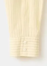 Camisa amarilla de manga larga con diseño cruzado y lazo para atar en la cintura.