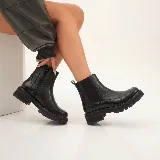Bota Chelsea de cuero vacuno color negro, con diseño de textura croco en la parte inferior y suela track de goma. Presenta elástico lateral externo y cierre interno para mayor comodidad.
