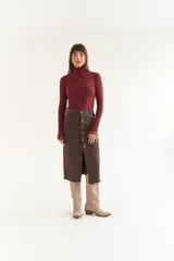 Polera de algodón color bordó, con cuello alto y mangas largas. Presenta un diseño ajustado al cuerpo con costuras visibles en los puños.