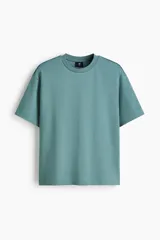 Remera de algodón color verde con cuello redondo ribeteado, mangas cortas y hombros caídos de corte holgado.