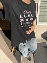 Remera oversize marrón con estampado gráfico frontal en tonos celestes y blancos con la leyenda "Only Fans", palmeras y estrellas.