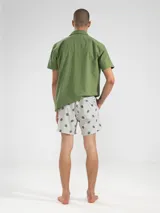 Short de baño celeste con rayas verticales blancas y estampado de flores blancas.