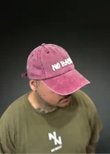 Gorra bordó con efecto gastado, visera curvada y bordado frontal en color blanco con la inscripción "No Basic". Cuenta con tira trasera ajustable.