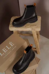 Botas tipo Chelsea de cuero color marrón con paneles elásticos laterales negros y suela track de goma negra con plataforma.