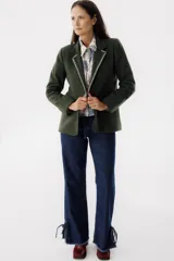 Blazer color verde oscuro con solapas con pespuntes blancos, de corte recto y cierre con un botón.