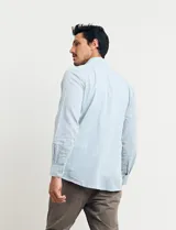 Camisa sport de manga larga con cuello buttondown, confeccionada en una mezcla de algodón y lino. Presenta un diseño clásico en color celeste con cierre frontal de botones.