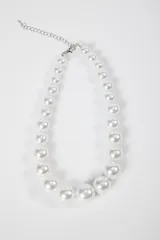 Collar de perlas blancas de distintos tamaños con cierre metálico plateado y cadena de alargue.