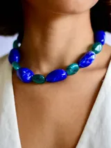 Collar de cuentas de resina en tonos azul y turquesa con acabado marmolado, montado sobre una cadena de acero quirúrgico ajustable.