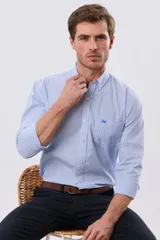 Camisa de manga larga con estampa de cuadros pequeños en tonos celeste y blanco, cuello con botones y bolsillo ojal en el pecho con detalle bordado.