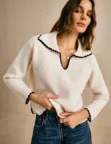 Sweater de punto color off white con cuello estilo sailor y detalles de borde festoneado en contraste negro en cuello, puños y ruedo. Presenta un diseño de manga larga y calce relajado.
