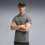 Chomba deportiva Puma del Club Peñarol, color gris con cuello polo y cierre de botones. Cuenta con el logo de Puma en amarillo en el pecho derecho y el escudo del club en el izquierdo.