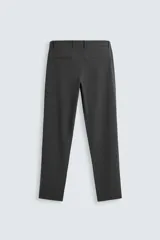 Pantalón de corte slim fit confeccionado en tejido elástico, con cintura elástica, cierre frontal con cremallera y botón, bolsillos laterales y bolsillos traseros de vivo.