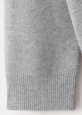 Cardigan gris de punto con escote en V, cierre frontal abotonado y mangas largas, diseño clásico y versátil.
