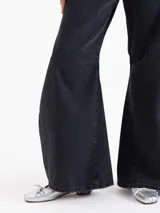 Jeans de corte wide leg y estilo balloon, color negro lavado. Presenta pinzas y recortes estratégicos en las piernas que aportan volumen y movimiento. De tiro medio, confeccionado en tejido de algodón liviano.