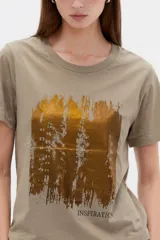 Remera de manga corta de algodón en color blanco, con cuello redondo y diseño holgado. Presenta un estampado frontal con detalle de acabado metálico (foil).
